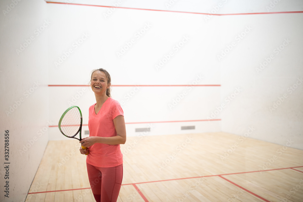 Pretty, female squash player on a squash court (motion blurred image; color toned image) Pretty, female squash player on a squash court (motion blurred image; color toned image)
