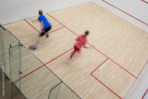 Squash players in action on a squash court (motion blurred image  color toned image) © lightpoet