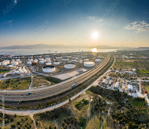 Aerial view of Chemical plant at sunset, oil refining, smoke, pipes, ecology pollution, air infection, coast of sea in Greece, Oil tankers expect loading