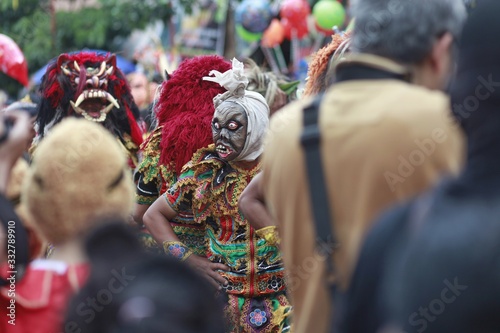 A teenager wears a scary Indonesian ghost mask commonly called Pocong in a cultural carnival