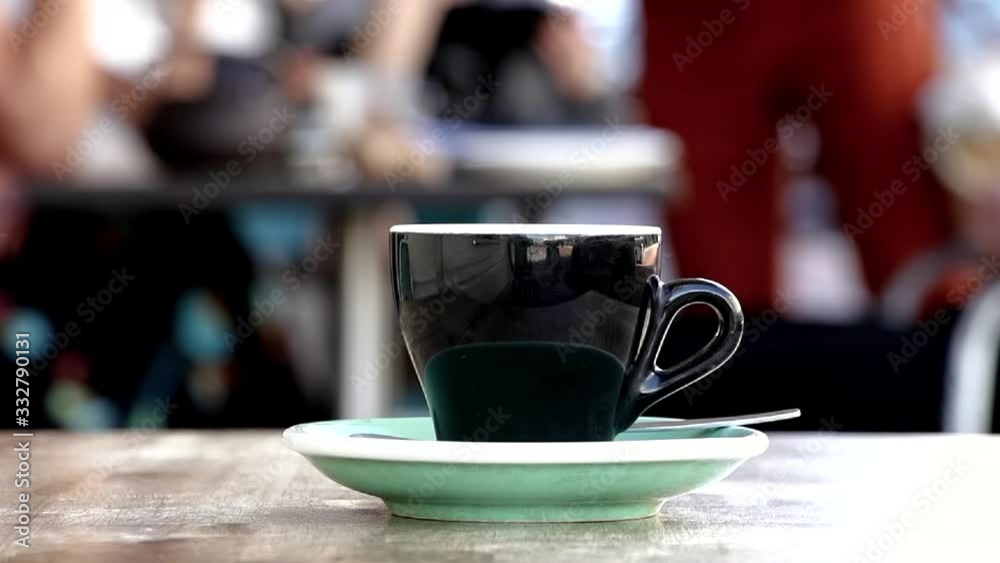A coffee cup with plate on a table, placed outdoors at a coffee shop. Coffee break concept. A coffee cup with plate on a table, placed outdoors at a coffee shop. Coffee break concept.