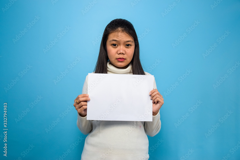 Portrait of Young beautiful asian women using white T-shirt with blue isolated background, hold and showing blank sign Portrait of Young beautiful asian women using white T-shirt with blue isolated background, hold and showing blank sign
