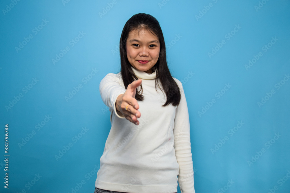 Portrait of Young beautiful asian women using white T-shirt with blue isolated background, offering handshake Portrait of Young beautiful asian women using white T-shirt with blue isolated background, offering handshake