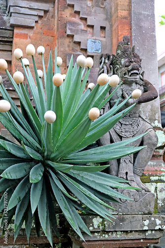 A stone entrance door decorated with stone statues of Balinese gods and demons photo