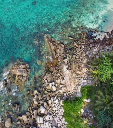Panoramic overhead downward aerial view of beautiful tropical beach with rocks