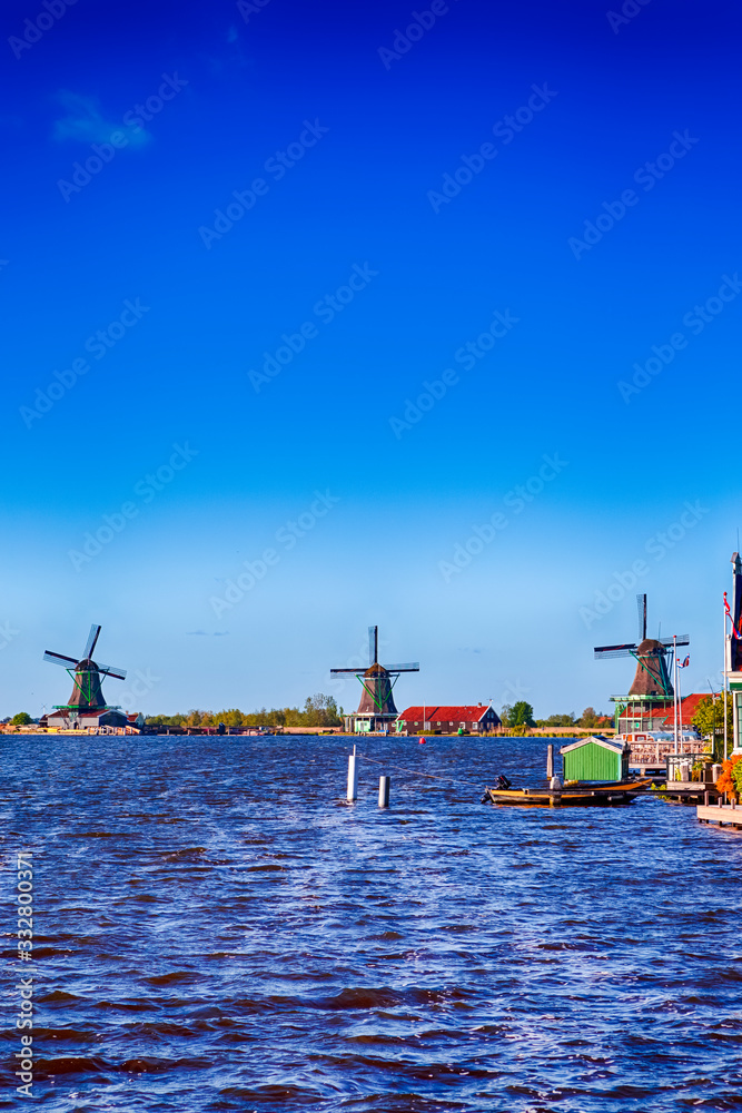Naklejka premium Dutch Travel Concepts. Traditional Dutch Windmills in the Village of Zaanse Schans at Daytime in the Netherlands.