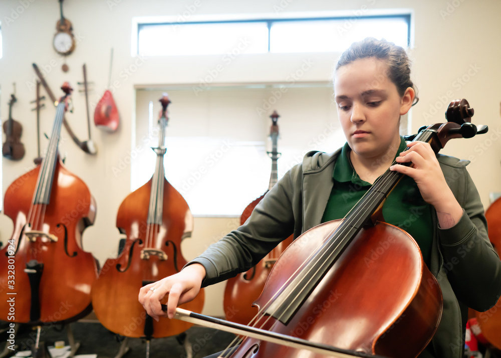 Teenage girl playing cello in classroom Teenage girl playing cello in classroom