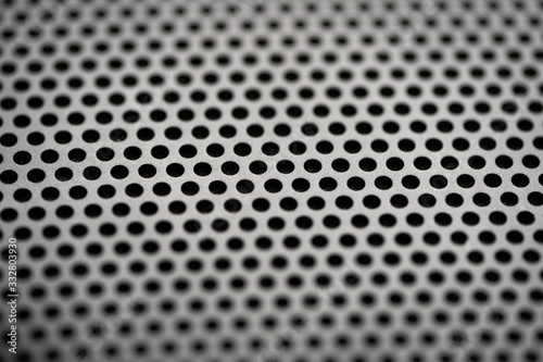 Black metal texture with round holes. Industrial background.