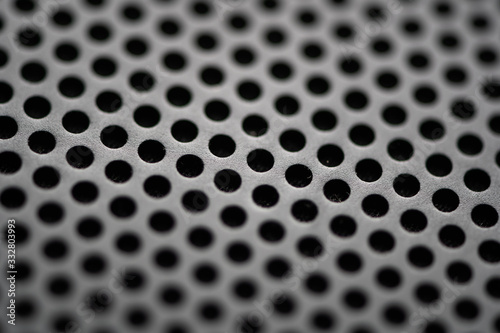 Black metal texture with round holes. Industrial background. © tonklafoto