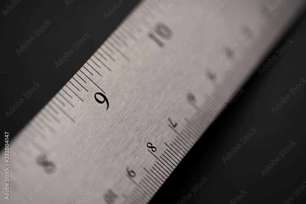 Metal ruler on a black leather isolated background with black numbers and scale. Show scale in black digit. Metal ruler on a black leather isolated background with black numbers and scale. Show scale in black digit.