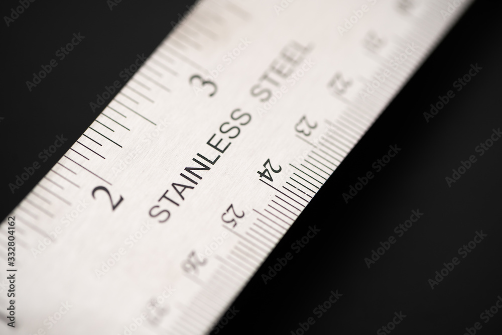 Metal ruler on a black leather isolated background with black numbers and scale. Show scale in black digit. Metal ruler on a black leather isolated background with black numbers and scale. Show scale in black digit.
