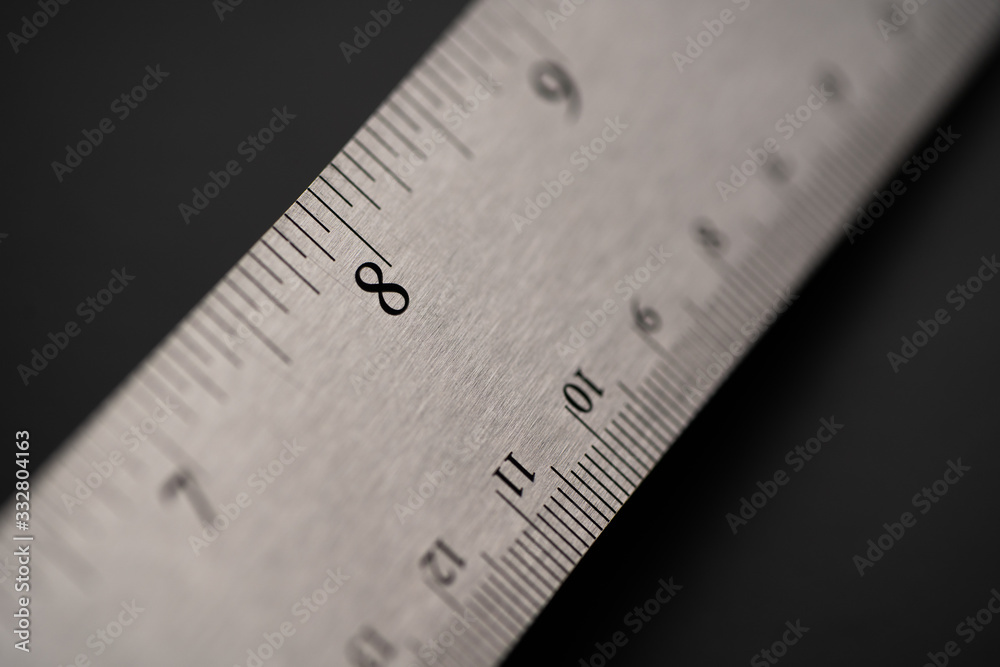 Metal ruler on a black leather isolated background with black numbers and scale. Show scale in black digit. Metal ruler on a black leather isolated background with black numbers and scale. Show scale in black digit.
