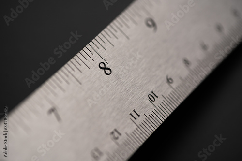 Metal ruler on a black leather isolated background with black numbers and scale. Show scale in black digit.