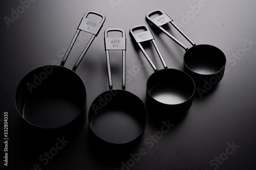 A set of black measuring cup on black background. photo