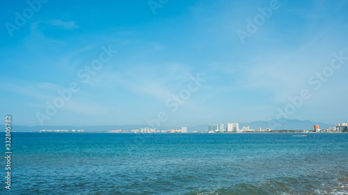 Bright Blue Ocean Beach With Buildings in the Background In Puerto Vallarta Mexico