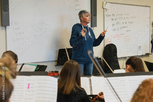 Music teacher conducting music class in classroom