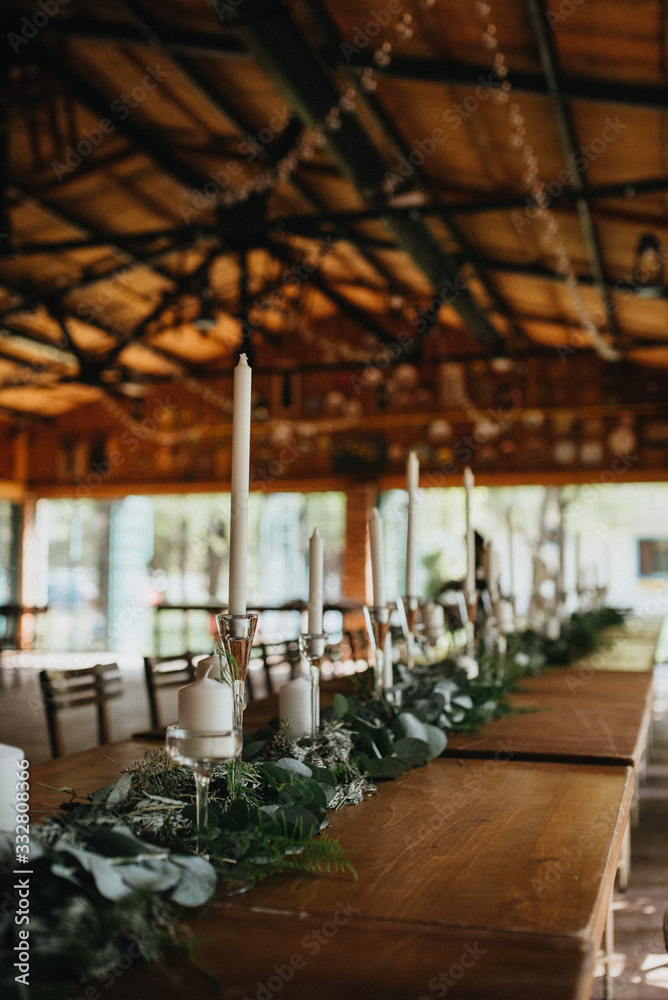 Fototapeta premium Decorated tables with candles and floral arrangements for celebration