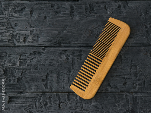 Wooden comb comb on a wooden background.