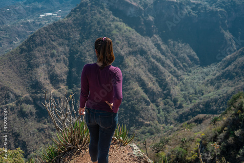 mujer al borde de un acantilado mirando al horizonte en mirador de Peña al aire en el estado de HIdalgo