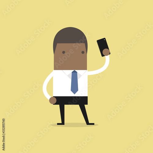African businessman taking selfie using a mobile phone.