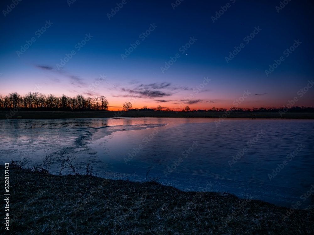 Icy Sunrise Over Pond