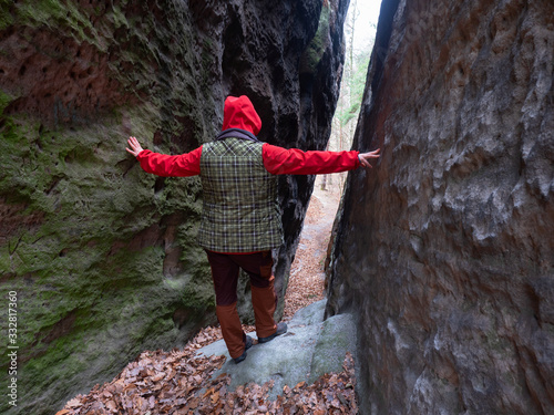 Girl touch rocky wall and stand between them