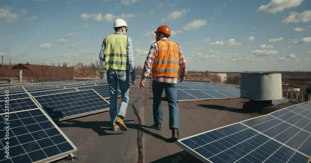 Engineer and technician discussing on flat roof Engineer and technician discussing on flat roof