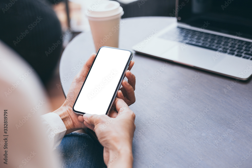 Mockup image blank white screen cell phone.woman hand holding texting using mobile on desk at coffee shop.background empty space for advertise text.people contact marketing business,technology