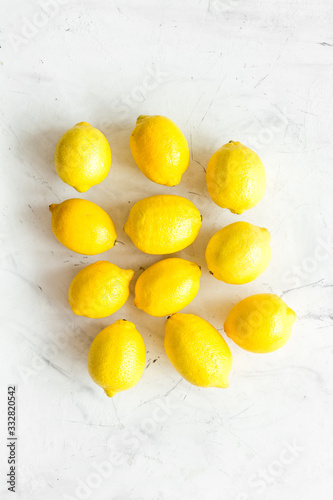 Lemons background - whole fruits - on white table top-down
