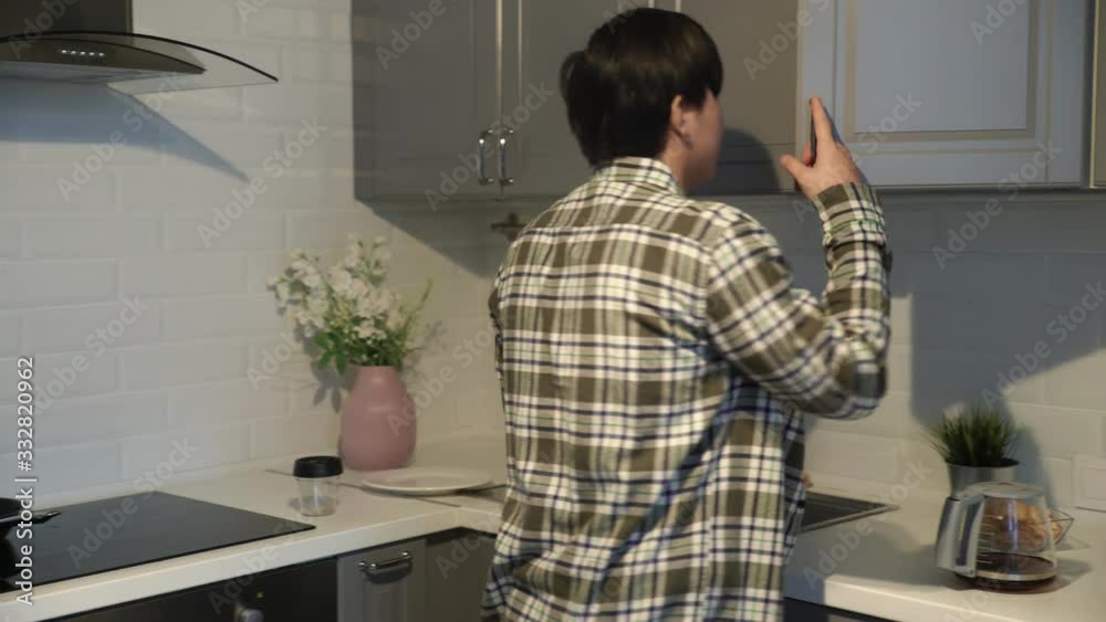 Young asian drinking coffee in kitchen at home Young asian drinking coffee in kitchen at home