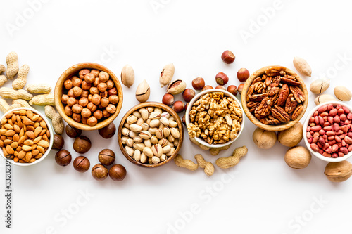 Set of macadamia, hazelnut, walnut, almond, pistachio, pecans nuts on white background top-down pattern copy space