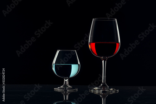 Copas de cristal con fondo negro y bebidas de color rojo y azul
