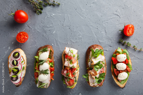 Bruschetta with tomatoes, bacon, herbs, mozzarella cheese , bell peppers, radishes and olives. This is a classic Italian snack. Hot and crunchy bread, rubbed with a head of garlic