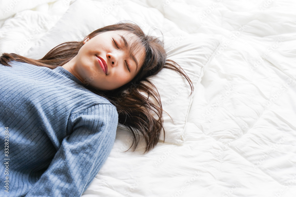 Obraz premium 布団に入って睡眠を取る若い女性