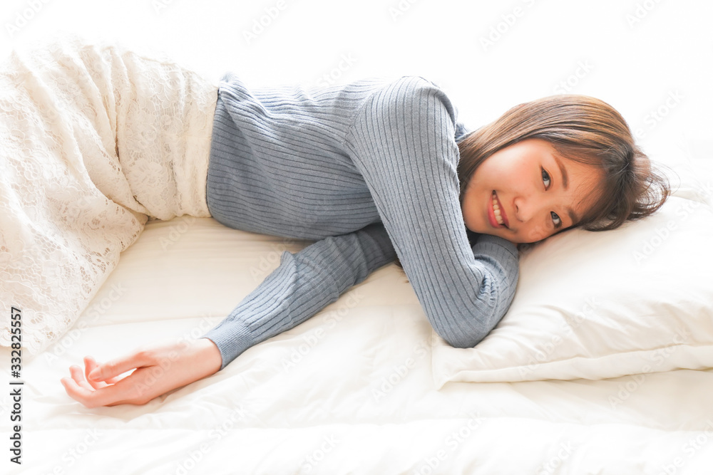 布団に入って睡眠を取る若い女性 布団に入って睡眠を取る若い女性