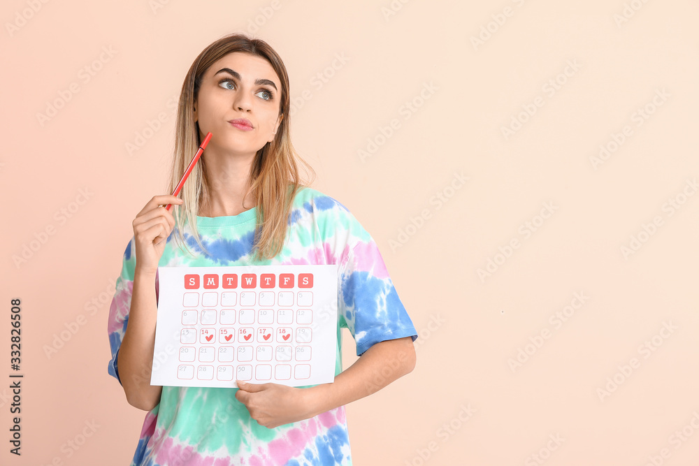 Young woman with menstrual calendar on color background Young woman with menstrual calendar on color background
