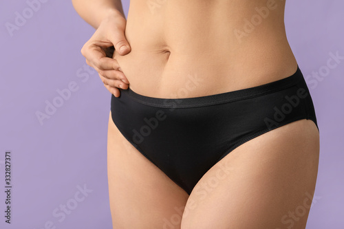Young woman with cellulite problem on color background, closeup © Pixel-Shot