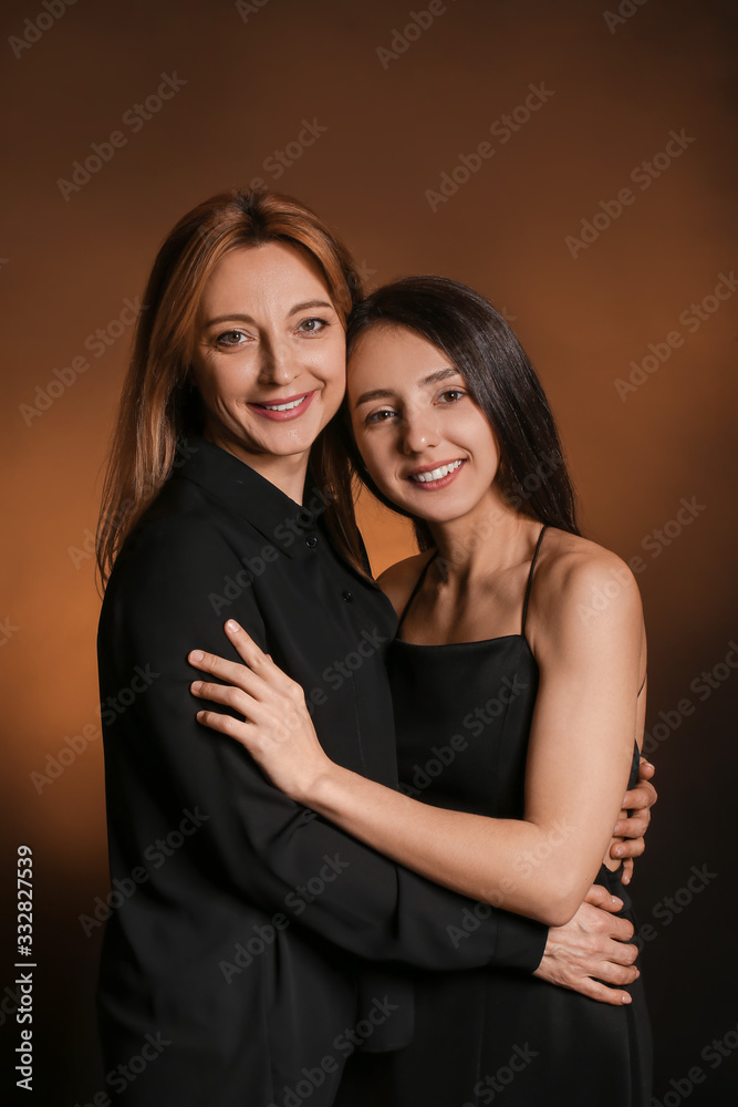 Portrait of young woman and mother on dark color background Portrait of young woman and mother on dark color background
