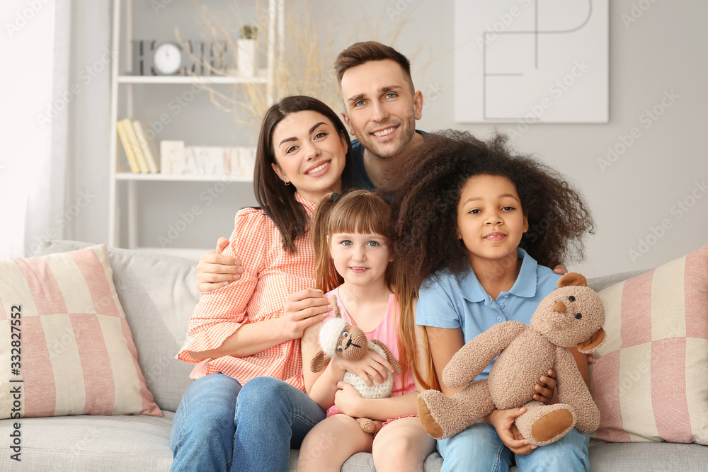 Happy couple with little adopted children at home Happy couple with little adopted children at home