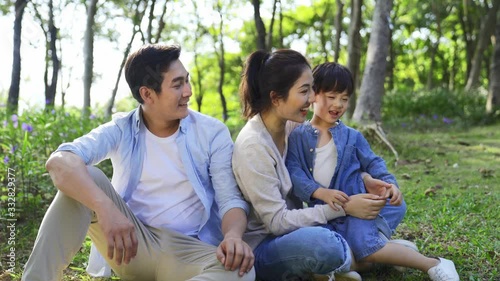 young asian parents and child enjoying nature outdoors in woods photo
