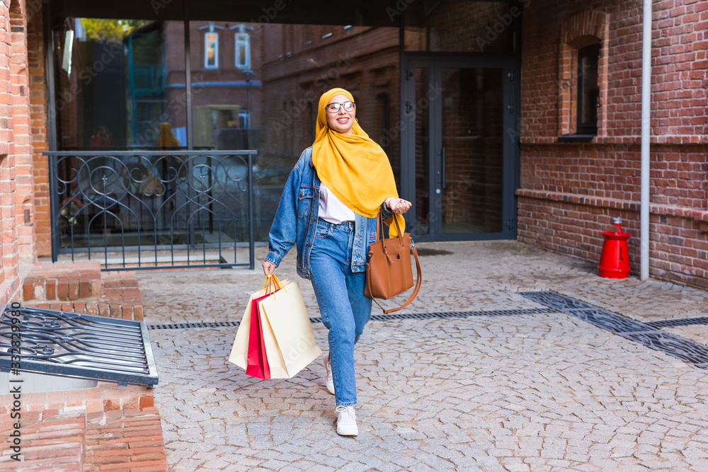 Sale and buying concept - Happy arab muslim girl with shopping bags after mall Sale and buying concept - Happy arab muslim girl with shopping bags after mall