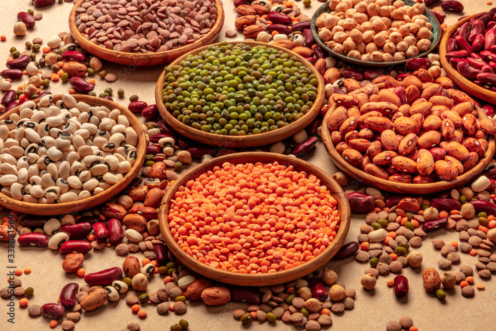 Legumes assortment on a brown background. Lentils, soybeans, chickpeas, red kidney beans, a vatiety of pulses Legumes assortment on a brown background. Lentils, soybeans, chickpeas, red kidney beans, a vatiety of pulses