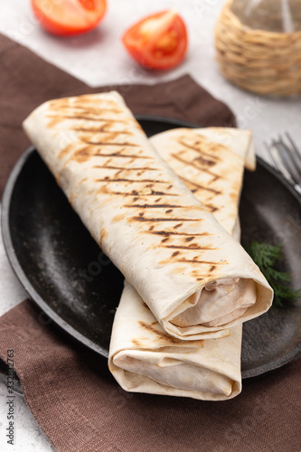 Shawerma guros with meat and vegetables on black plate