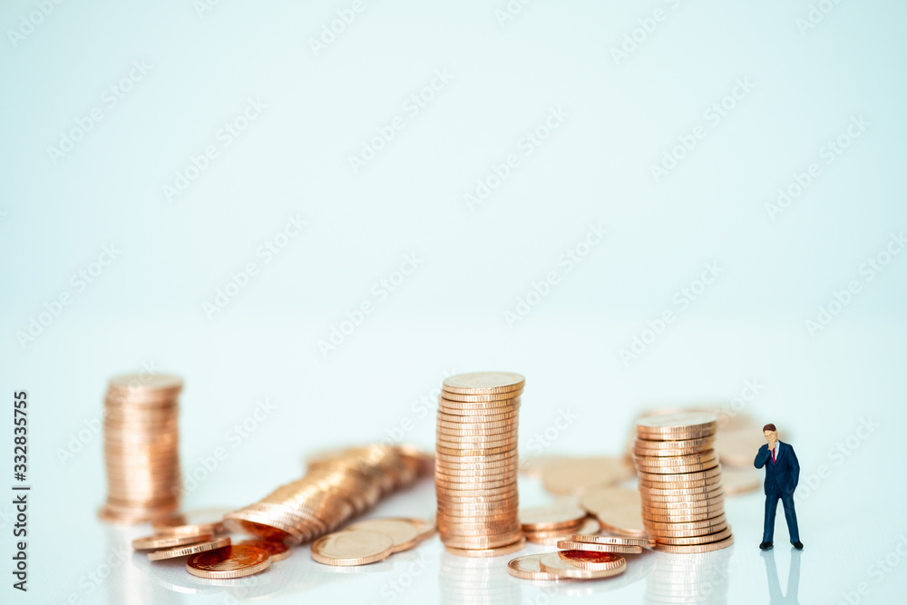 Miniature people: Businessman looking coins with copy space for text using as background saving, investment, money, financial, business analytics concept. Miniature people: Businessman looking coins with copy space for text using as background saving, investment, money, financial, business analytics concept.