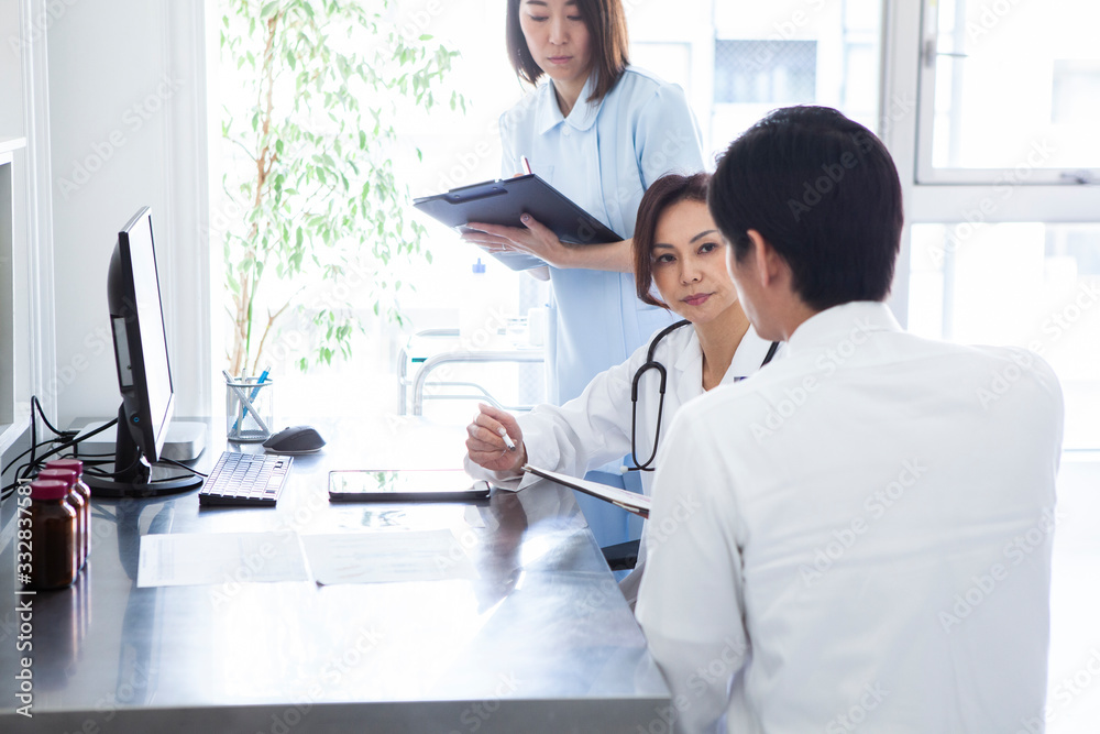 Obraz premium 患者の病状を聞く女医と看護師
