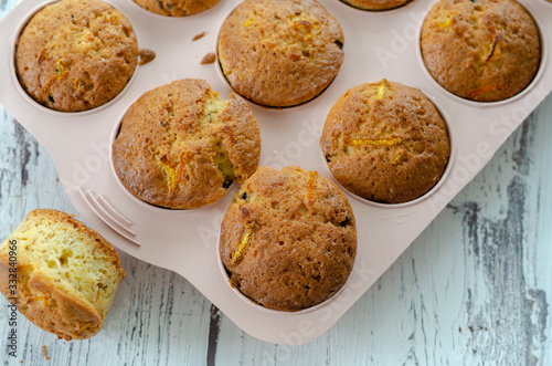 Delicious muffin with orange on a wooden table.