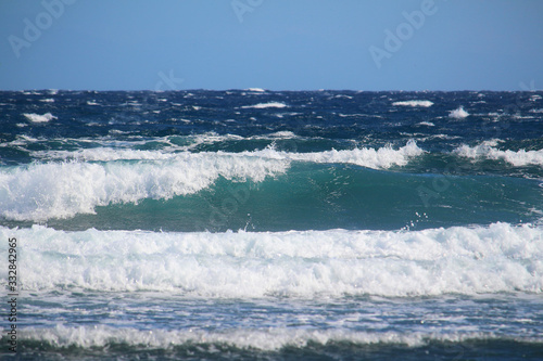 Fototapeta Naklejka Na Ścianę i Meble -  Turquoise and blue ocean waves with white foam till the horizon