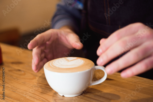 Barista pouring milk in coffee cup for make latte art.