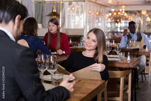 Woman with man discussing restaurant menu