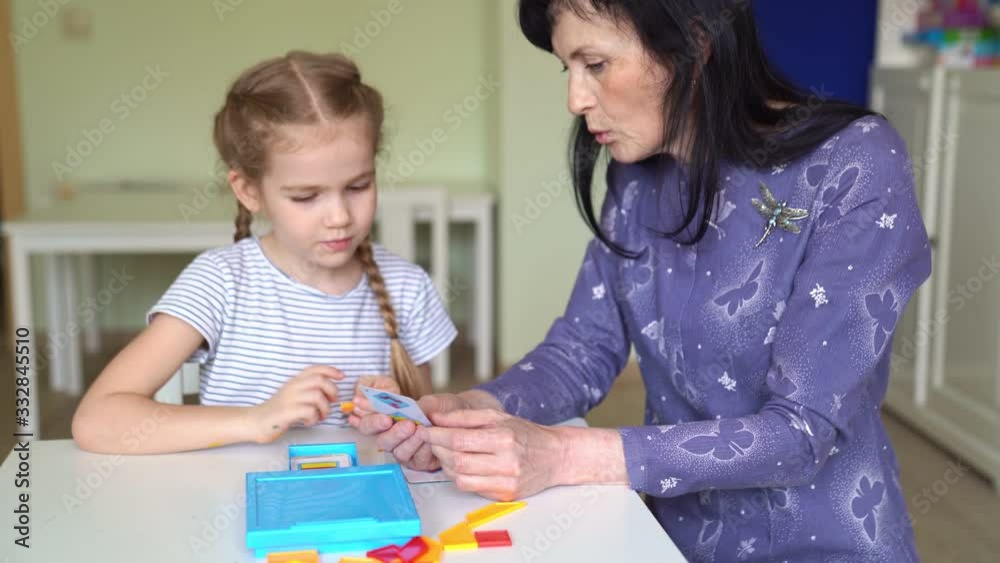 teacher and little girl solve mathematical puzzle teacher and little girl solve mathematical puzzle